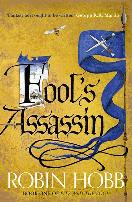 Fool's Assassin golden cover with gothic title, the first letter is illuminated, a flag to the right of the page